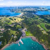 Aerial view of blue waters, yachts and a green island